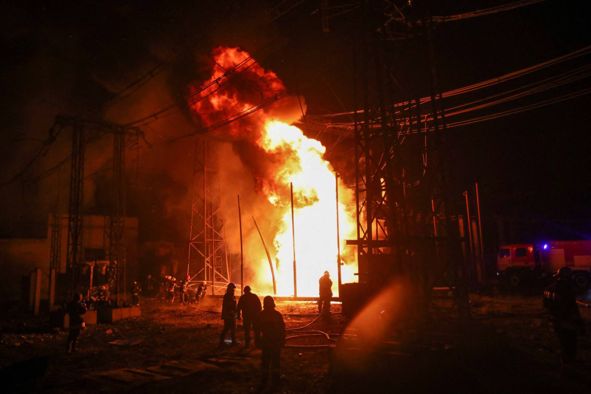 Firefighters work at a site of a thermal power plant damaged by a Russian missile strike in Kharkiv