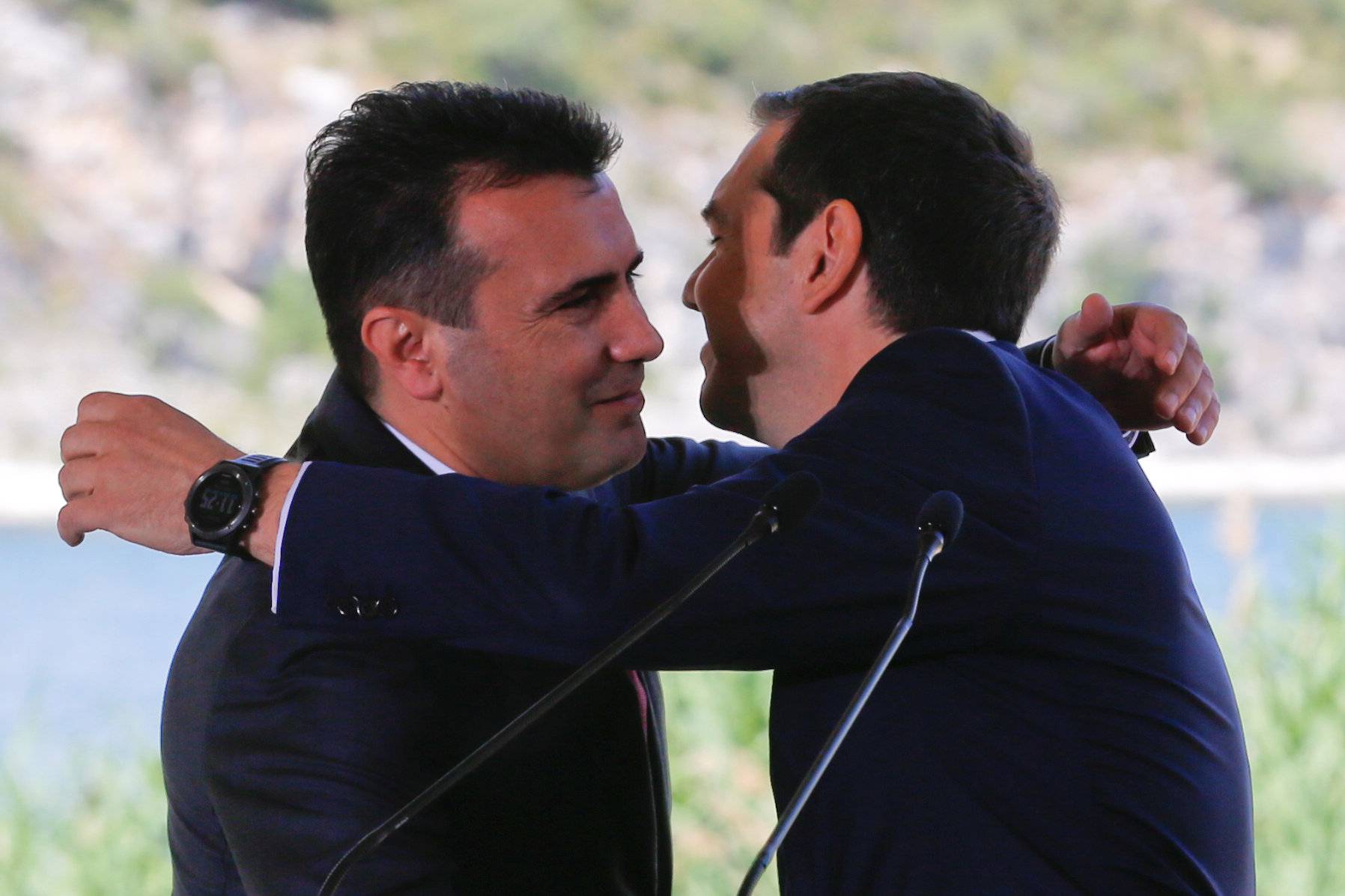 Greek Prime Minister Alexis Tsipras and Macedonian Prime Minister Zoran Zaev hug before the signing of an accord to settle a long dispute over the former Yugoslav republic's name in the village of Psarades