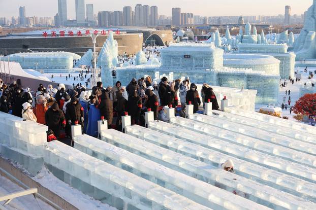 People stand in line for the giant ice slides at the annual Ice and Snow Festival in Harbin