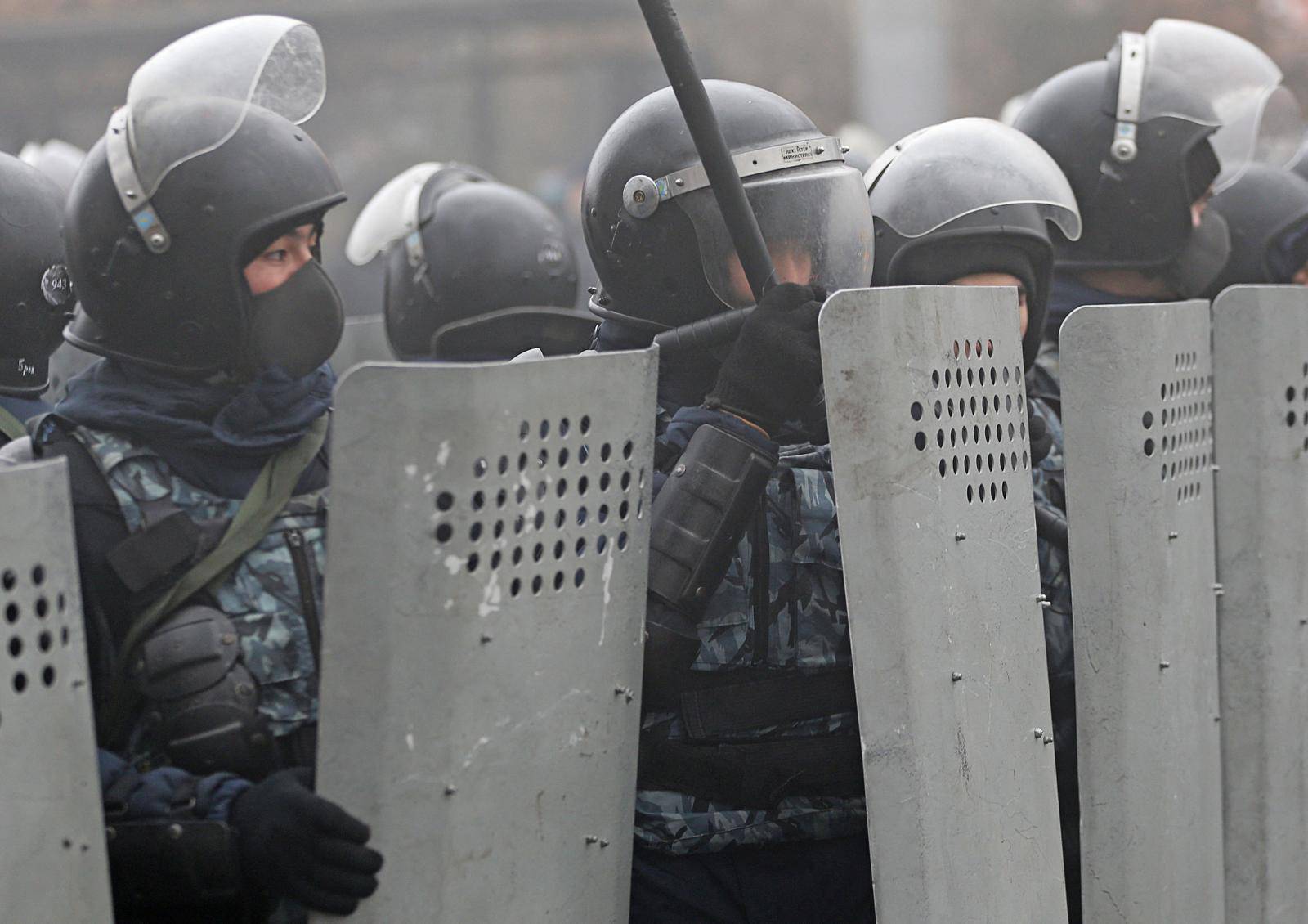 Kazakh law enforcement officers block a street during a protest triggered by fuel price increase in Almaty