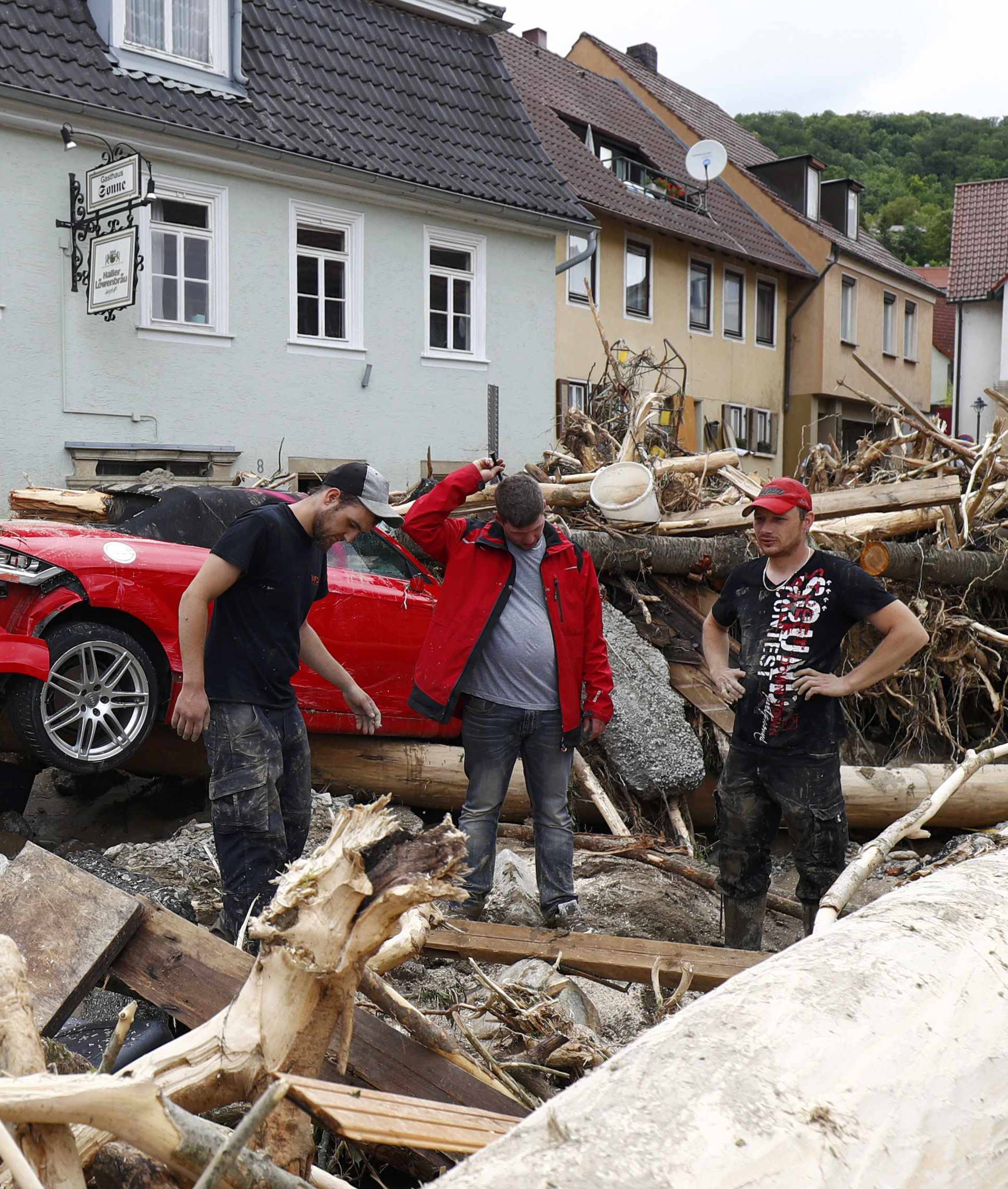 People look at the damage caused by the floods in the town of Braunsbach in Baden-Wuerttemberg