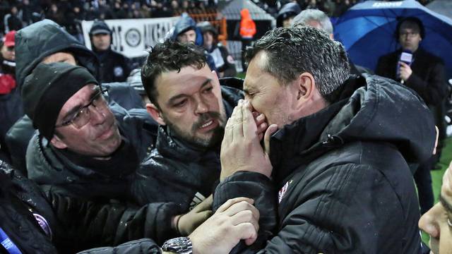 Olympiacos coach Oscar Garcia reacts after his injury during a Greek Super League soccer match between PAOK and Olympiacos in Thessaloniki