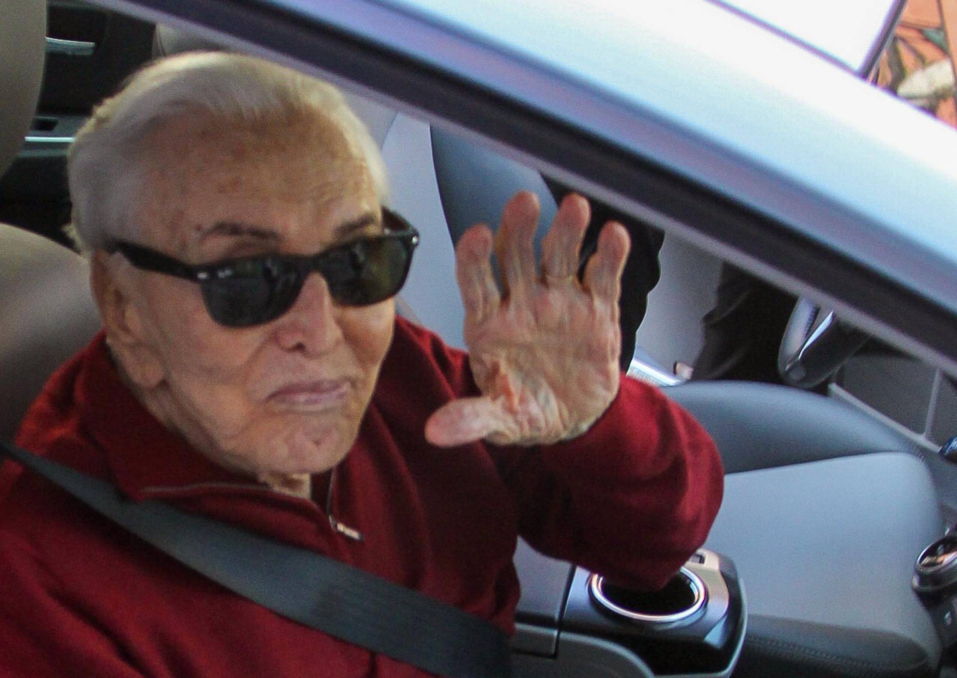 A spry 99 year old Kirk Douglas waves goodbye after a trip to his doctor