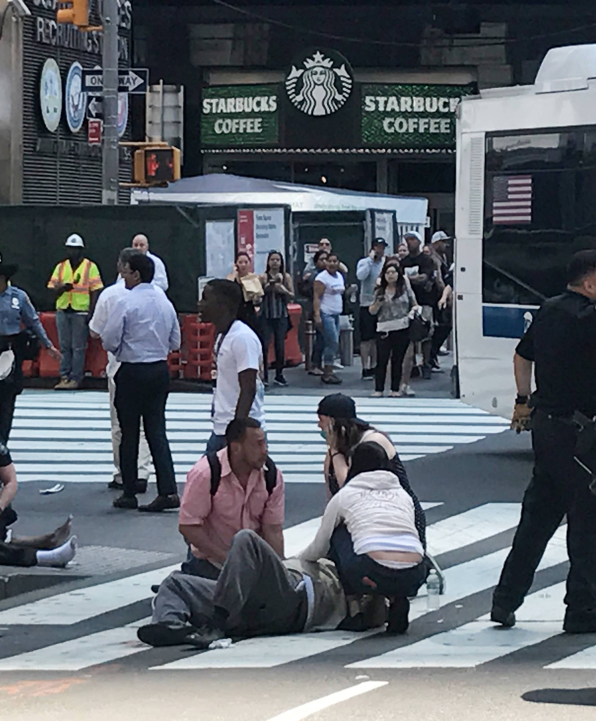 First responders are at the scene as people help injured pedestrians after a vehicle struck pedestrians on a sidewalk in Times Square in New York