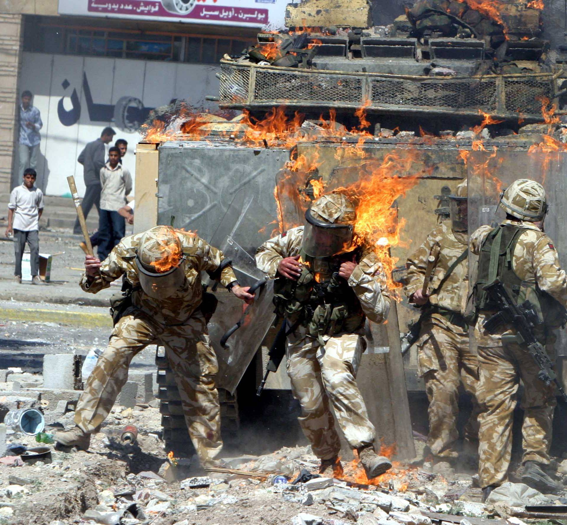 File photo of British Army troops covered in flames from a petrol bomb thrown during a violent protest by job seekers in Basra