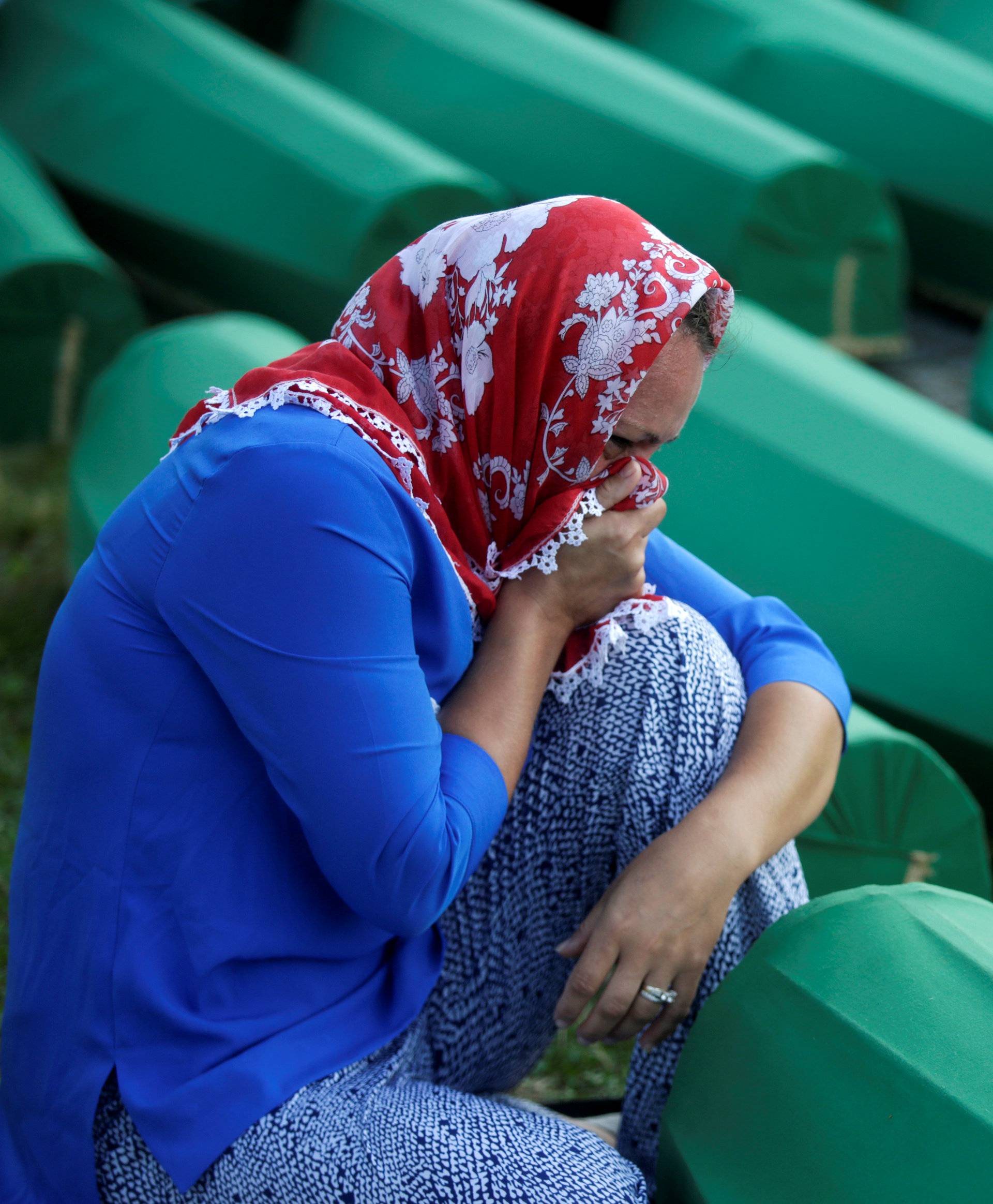 Muslim woman cry near coffins of their relatives, who are newly identified victims of the 1995 Srebrenica massacre, which are lined up for a joint burial in Potocari near Srebrenica