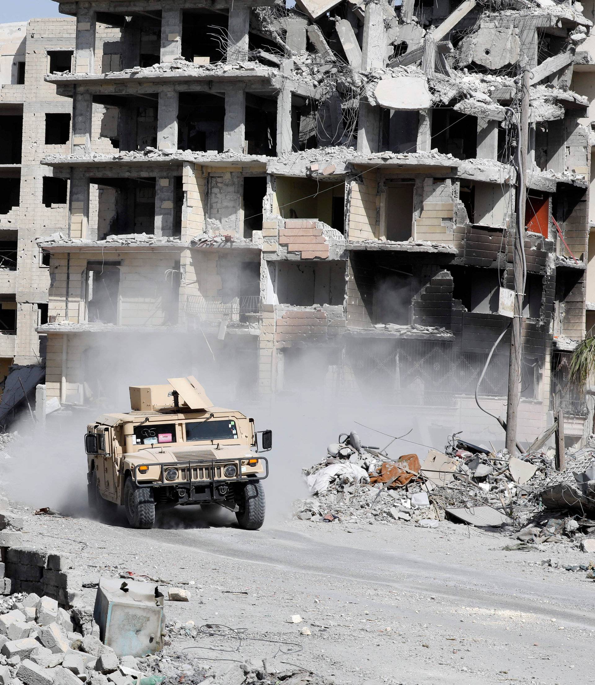 An armoured vehicle of the Syrian Democratic Forces is seen along a road at the frontline in Raqqa