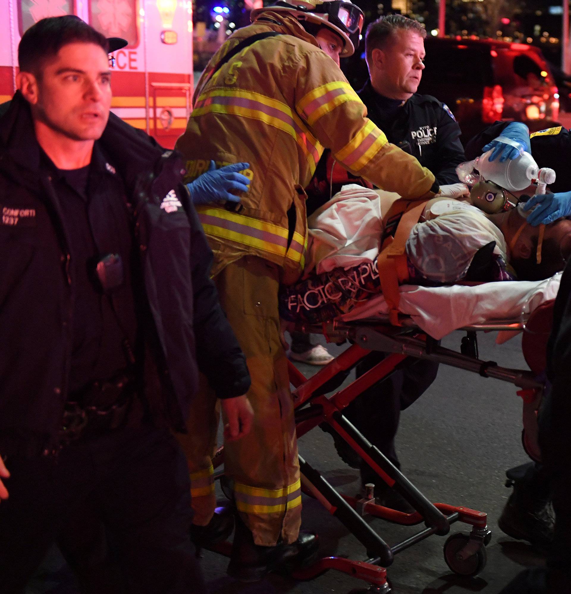 Paramedics and members of the FDNY perform CPR on a victim of a helicopter that crashed into the East River in New York