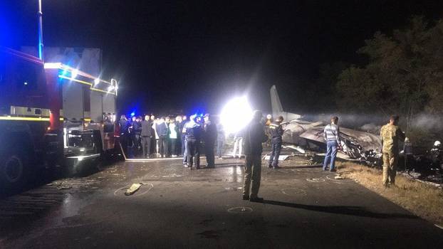Investigators work at the crash site of the Ukrainian military Antonov An-26 plane outside of Chuhuiv town