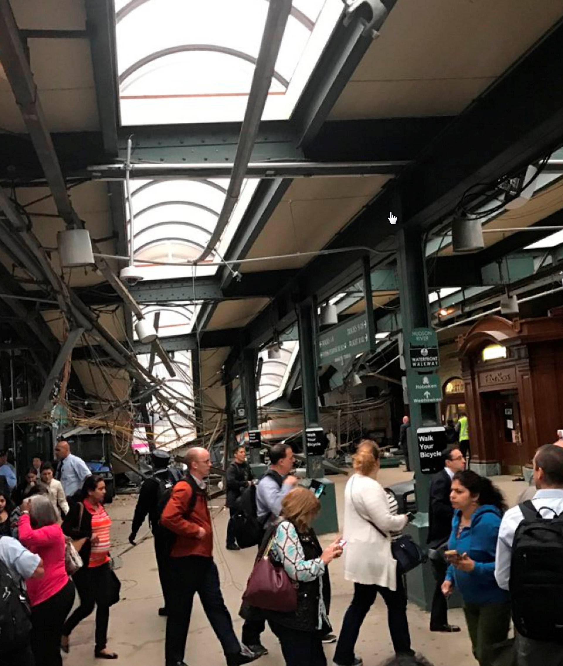 Onlookers view a New Jersey Transit train that derailed and crashed through the station in Hoboken