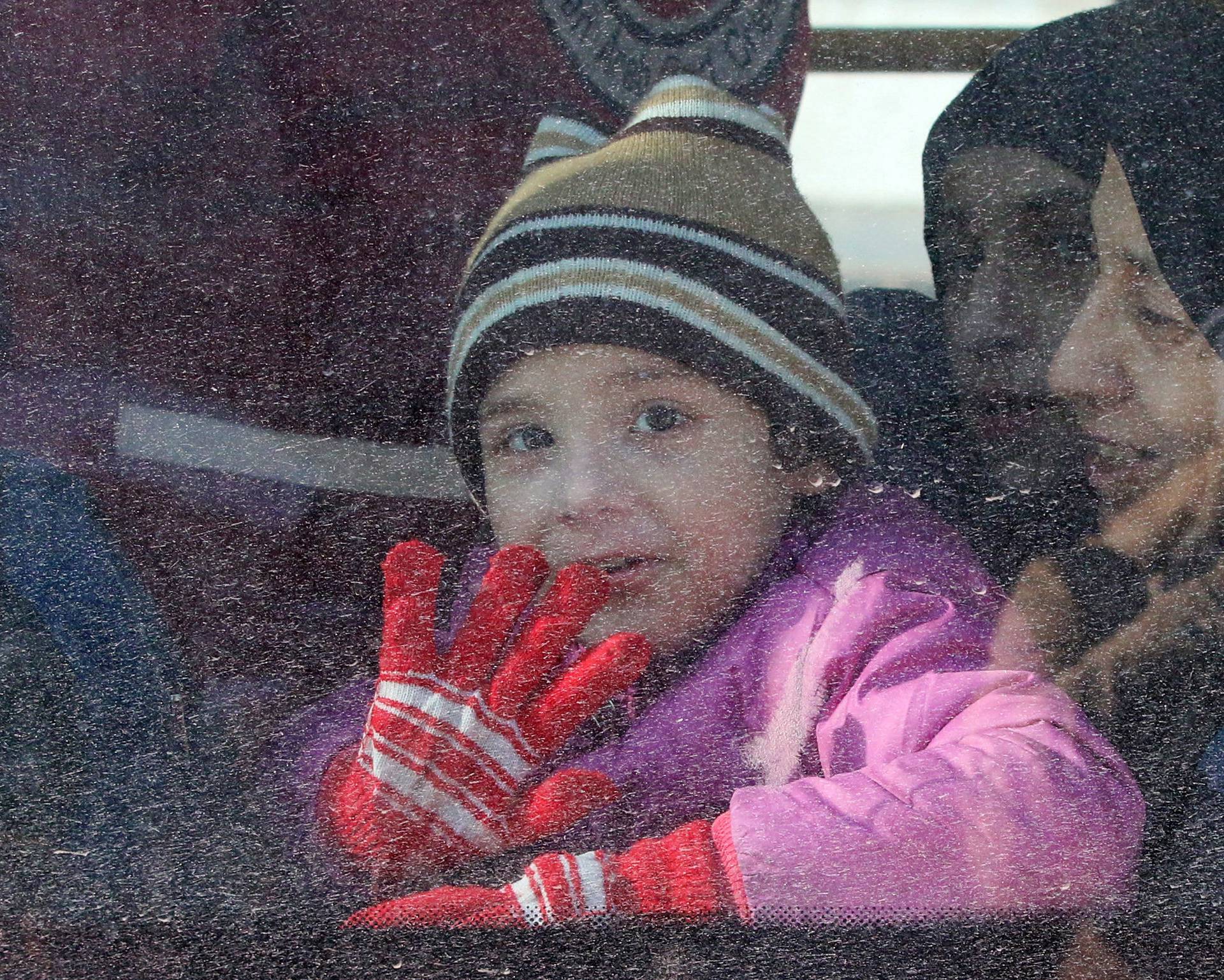 A child reacts from inside a bus evacuating people from a rebel-held sector of eastern Aleppo