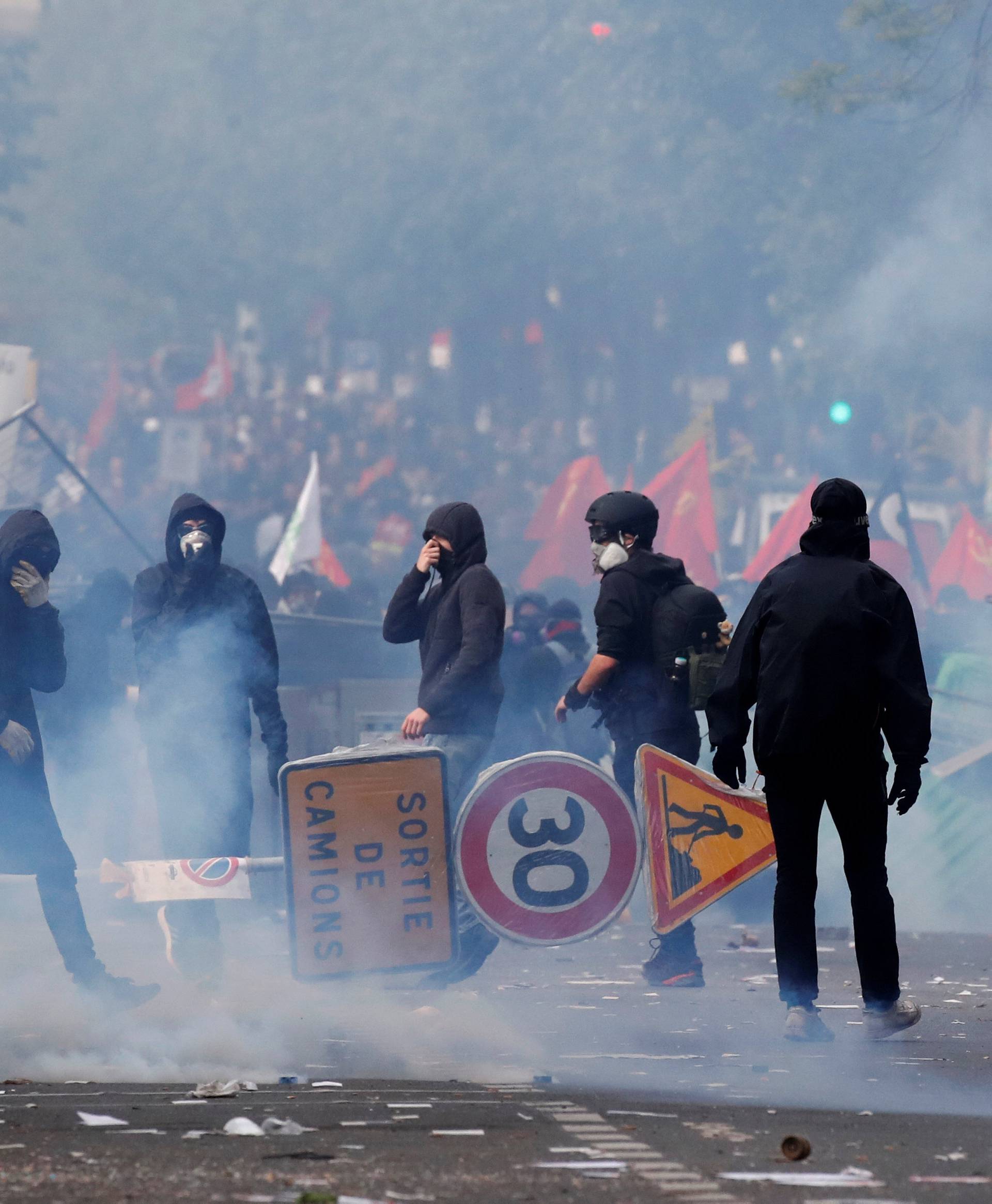 Tear gas surrounds protesters during clashes with French riot police at the May Day labour union rally in Paris