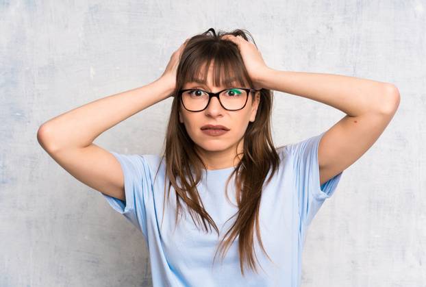 Young woman on grunge background with surprise facial expression