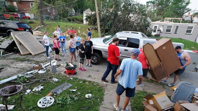 People rescue items from a home following a tornado in Jefferson City
