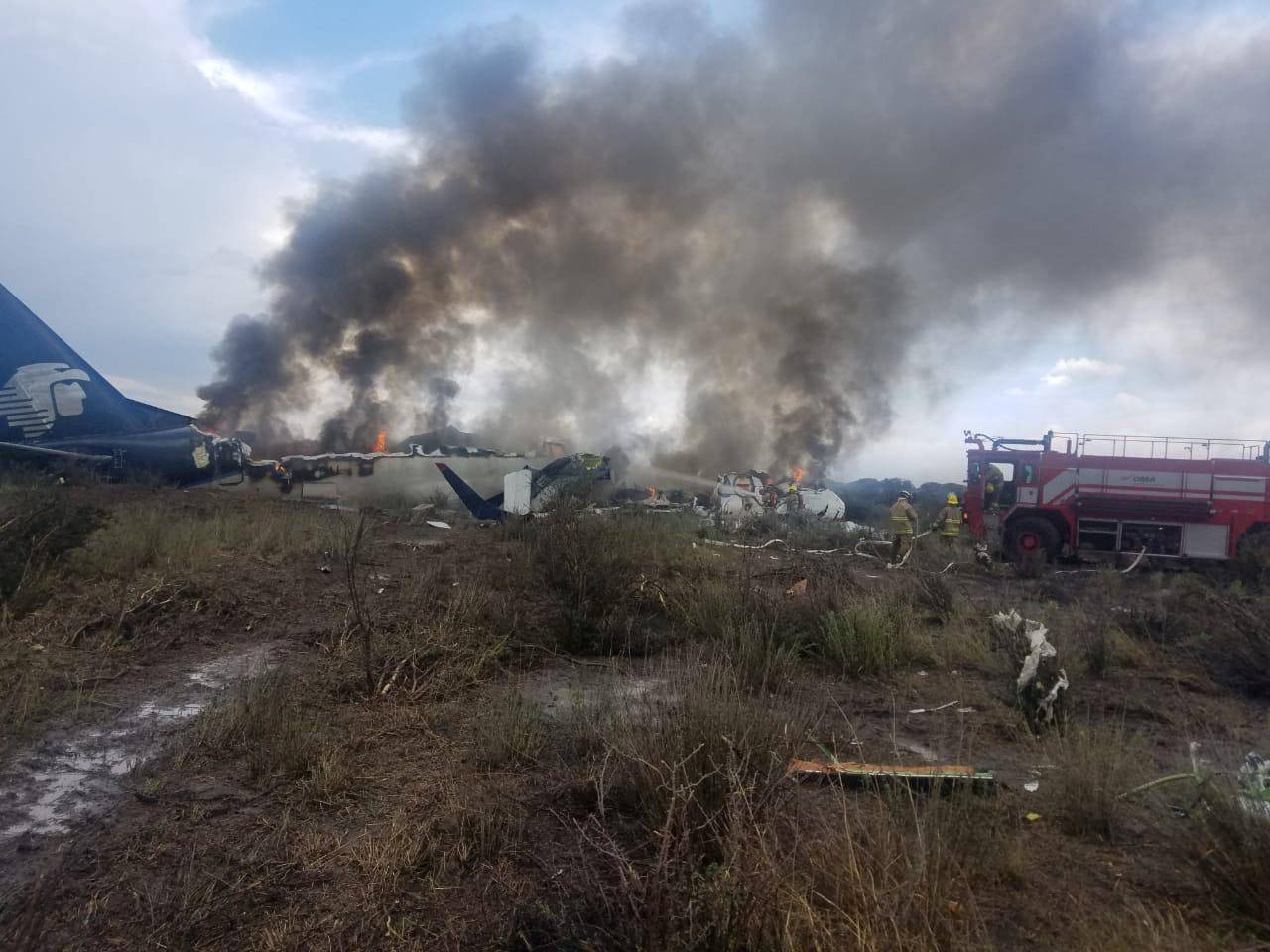 Firefighters douse a fire at the site where an Aeromexico-operated Embraer passenger jet crashed in Mexico's northern state of Durango
