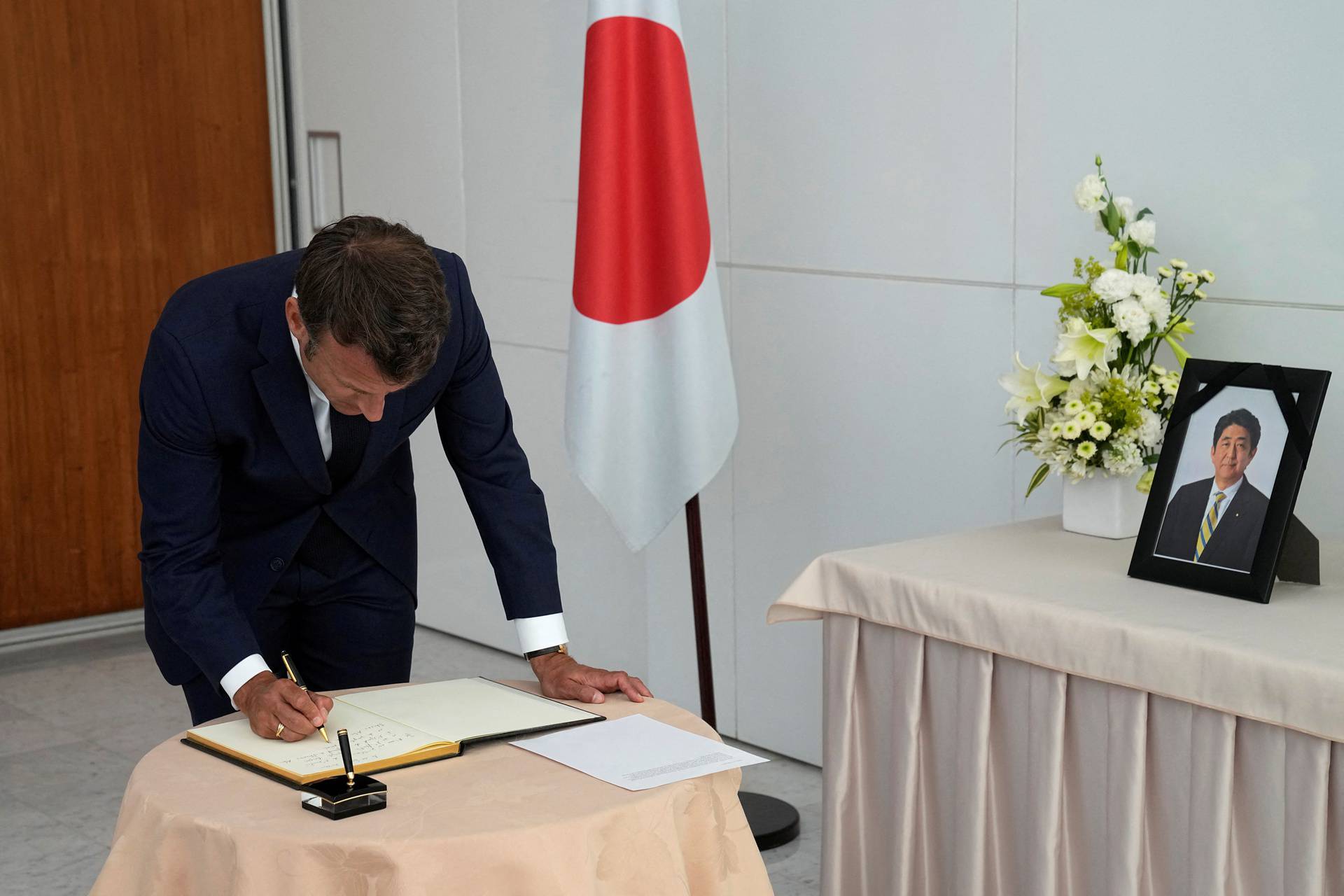 French President Emmanuel Macron signs a condolences book for late Japanese Prime Minister Shinzo Abe at the residence of Japan’s ambassador to France in Paris