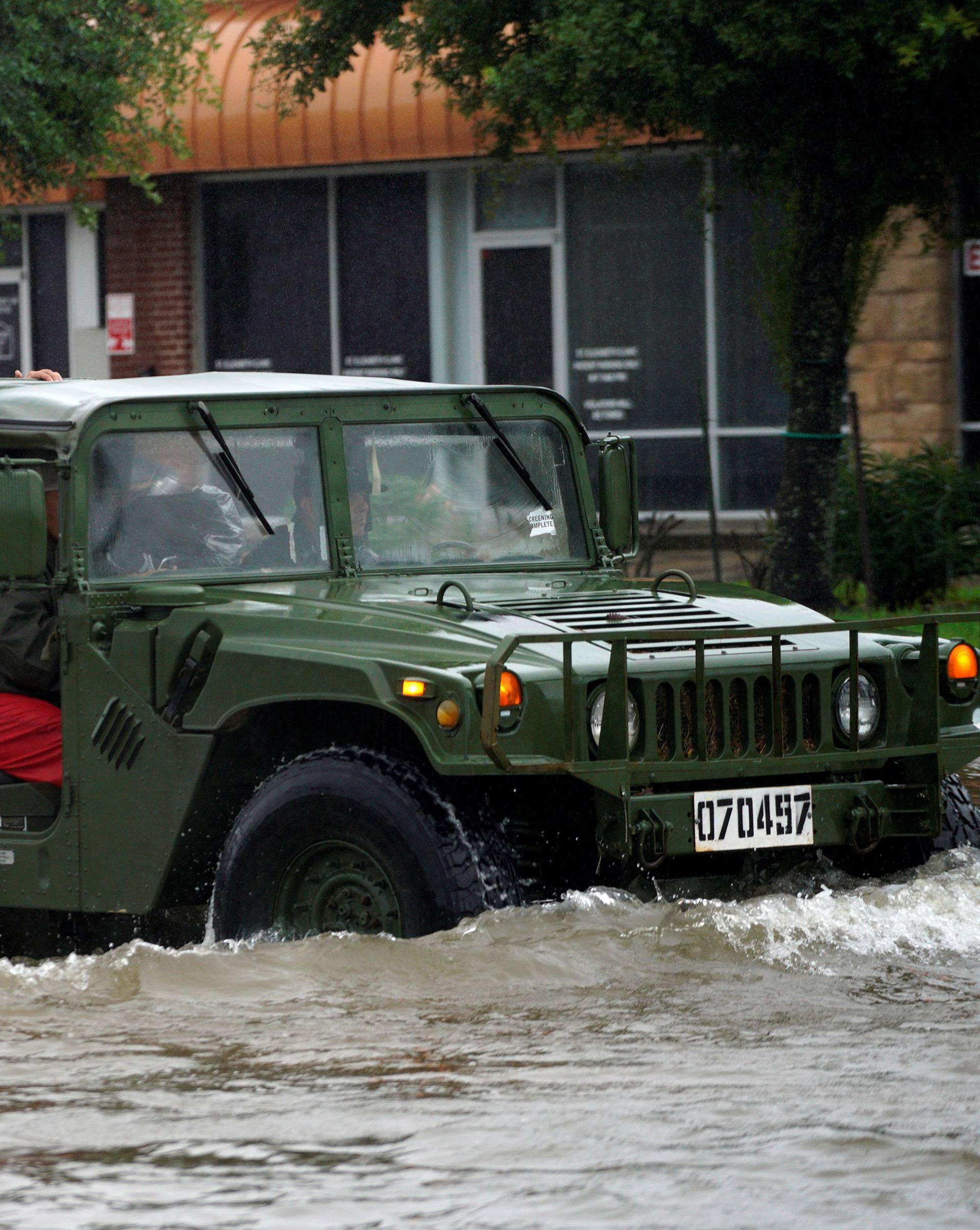 People are evacuated by a high water vehicle from the Hurricane Harvey floodwaters in Dickinson