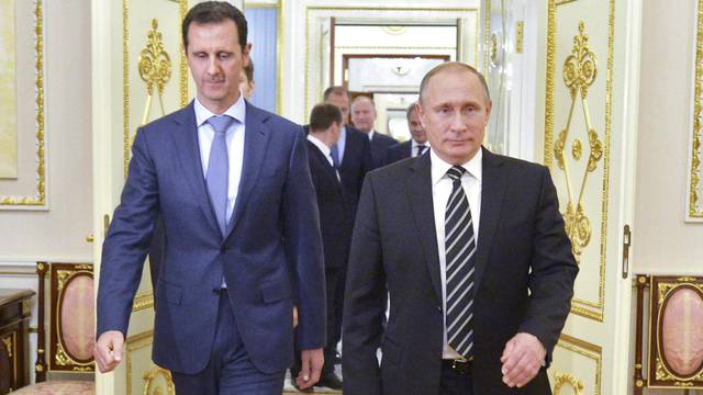 Russian President Vladimir Putin and Syrian President Bashar al-Assad enter a hall during a meeting at the Kremlin