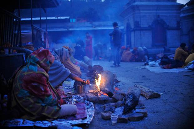 Kathmandu, Nepal. 24th Feb, 2017. Hindu Sadhus or Holy Man warm themselves on fire at the premises of Pashupatinath Temple in the early morning during the celebration of Maha Shivaratri Festival at Kathmandu, Nepal on Friday, February 24, 2017. Thousands 