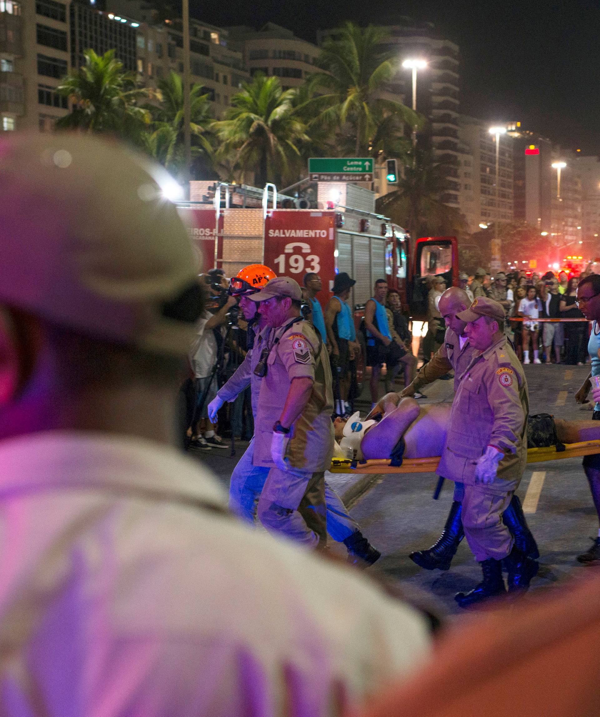 Paramedics help an injured after a vehicle ran over some people at Copacabana beach in Rio de Janeiro