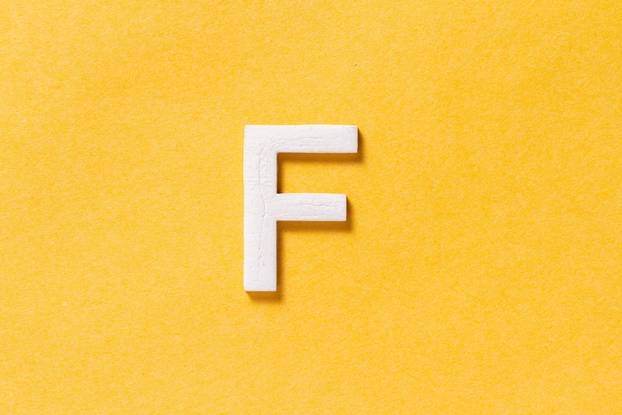 Letter F of the alphabet isolated on yellow background, top view