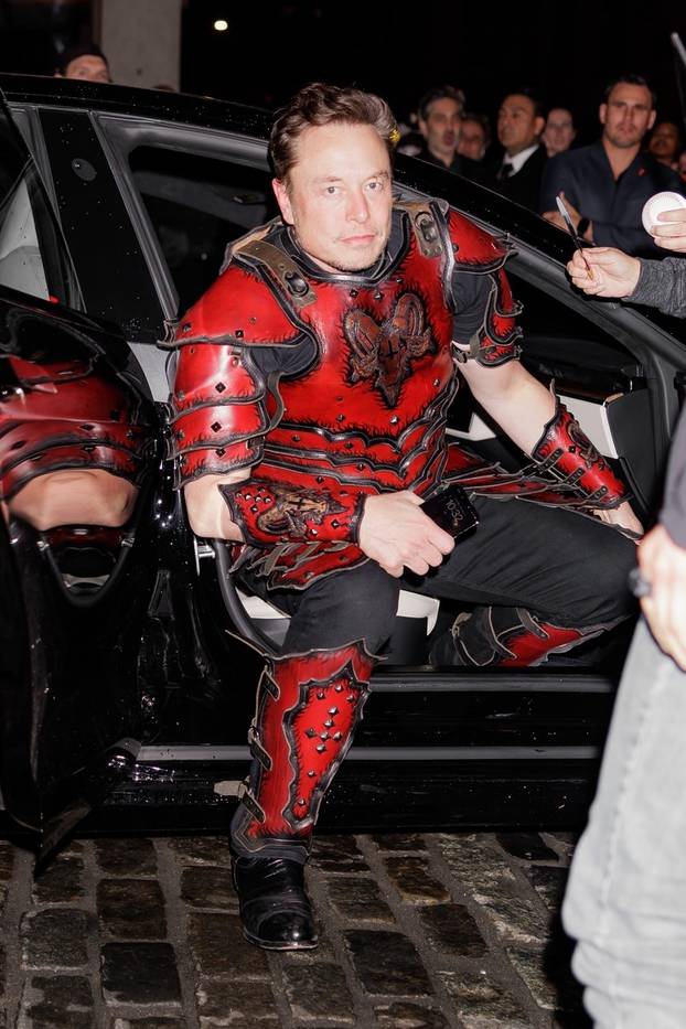 Elon Musk wears a knight costume with an upside-down cross on the back as he arrives at Heidi Klum’s Halloween party in NYC