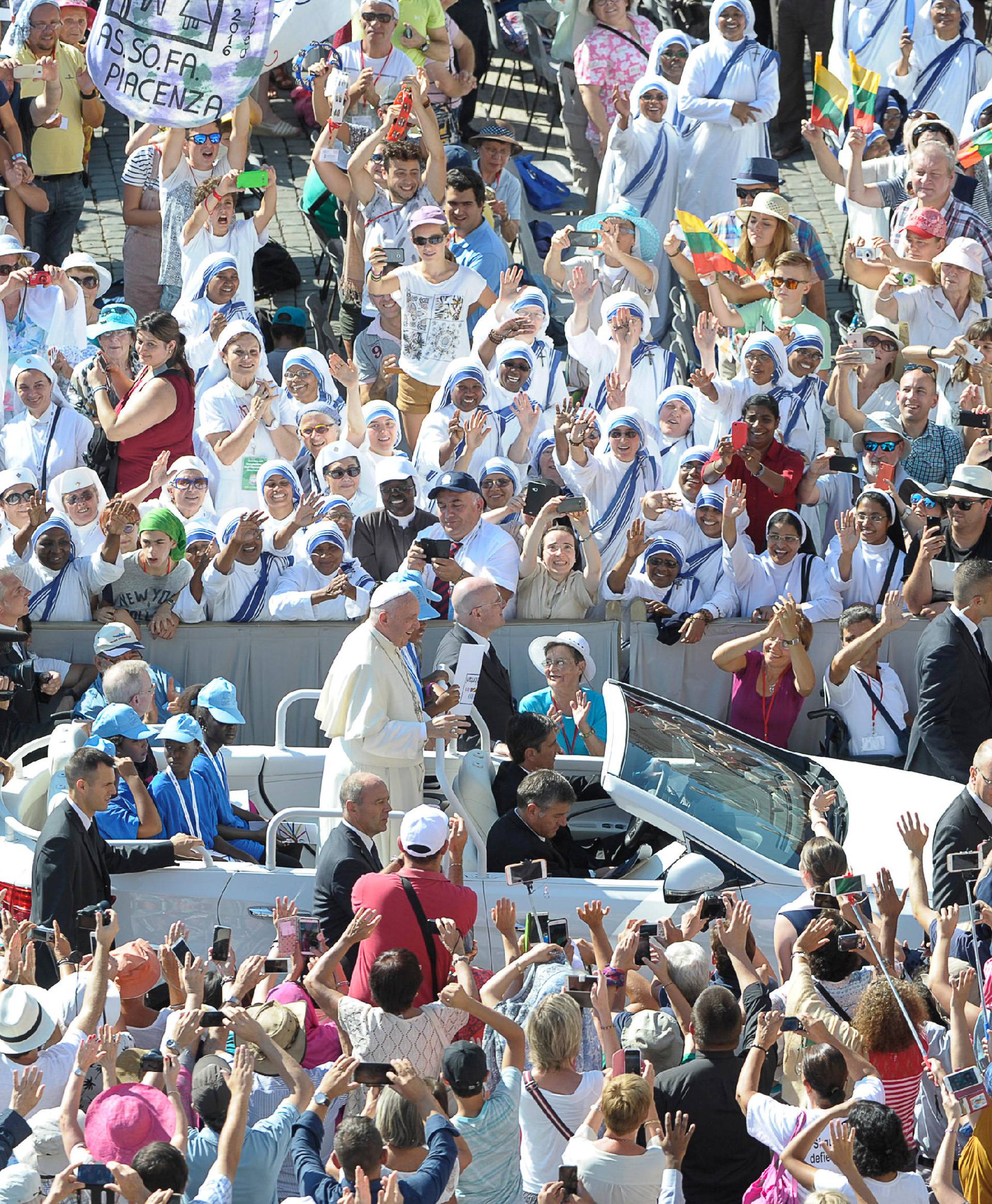 Pope Francis waves as he arrives for  the audience for workers ad volunteers of Mercy at the Vatican