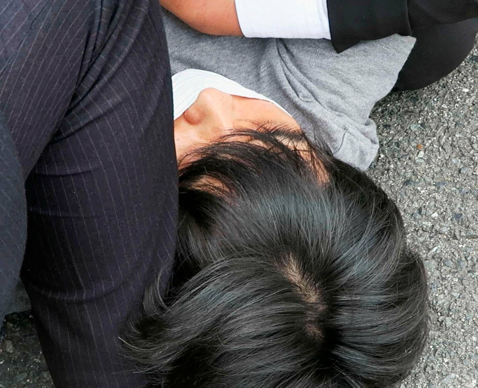 This screen grab shows the suspect, identified as Tetsuya Yamagami, believed to have shot former Japanese Prime Minister Shinzo Abe, being held by police officers in Nara