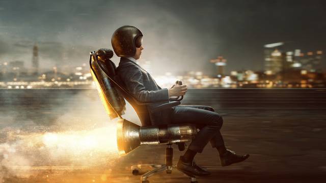 Businessman,Rolls,On,Office,Chair,With,Rocket,Motor