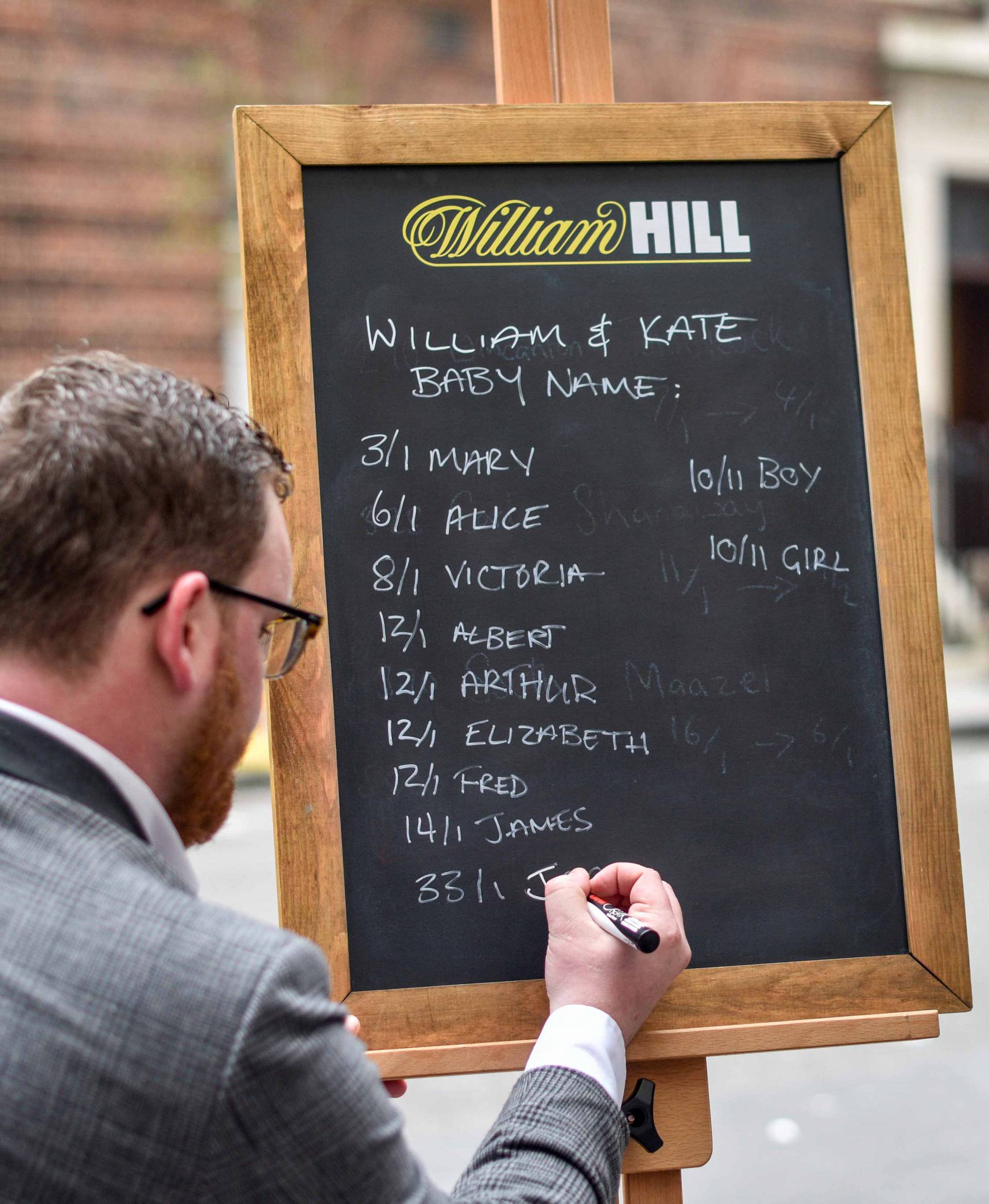 Joe Crilly, a spokesperson from the bookmaker William Hill, writes the names and betting odds for the third royal baby of Britain's Prince William and Catherine, Duchess of Cambridge, on a board outside the Lindo Wing St Mary's Hospital in west London
