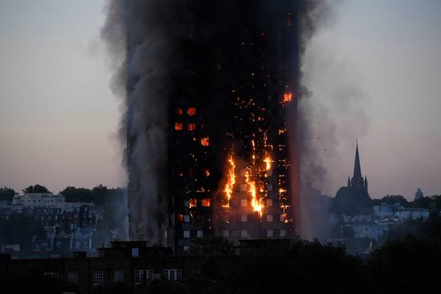 Flames and smoke billow as firefighters deal with a serious fire in a tower block at Latimer Road in West London