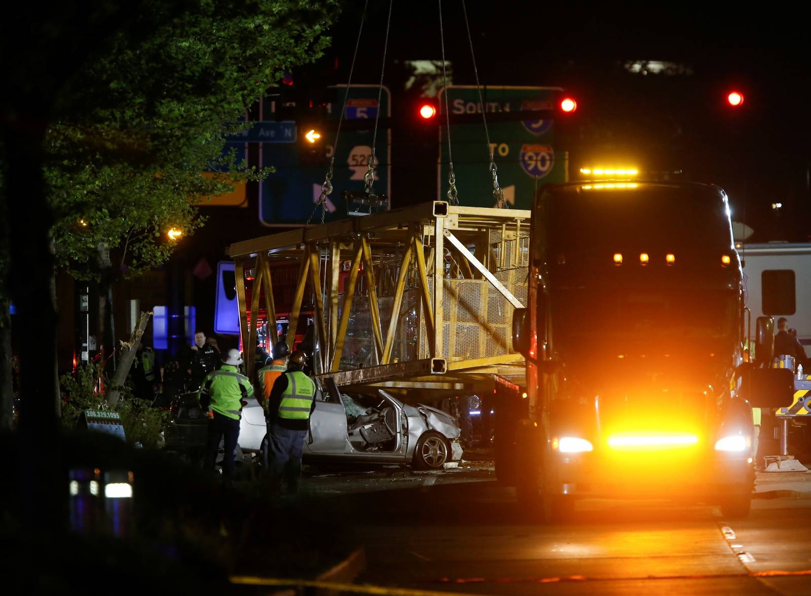 Part of a construction crane that fell in a deadly accident is removed from the scene on Mercer Street in Seattle