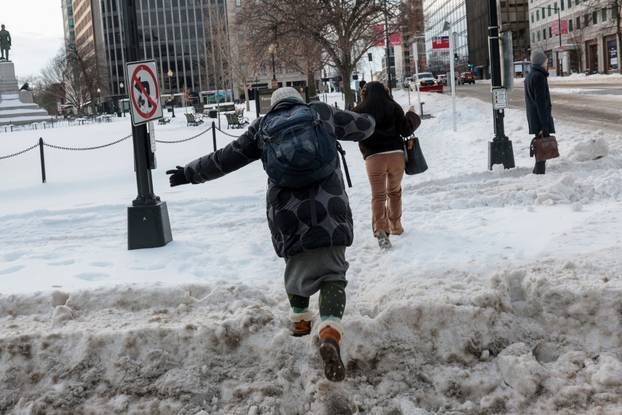 Commuters make their way though snow and ice in the aftermath of a winter storm in Washington