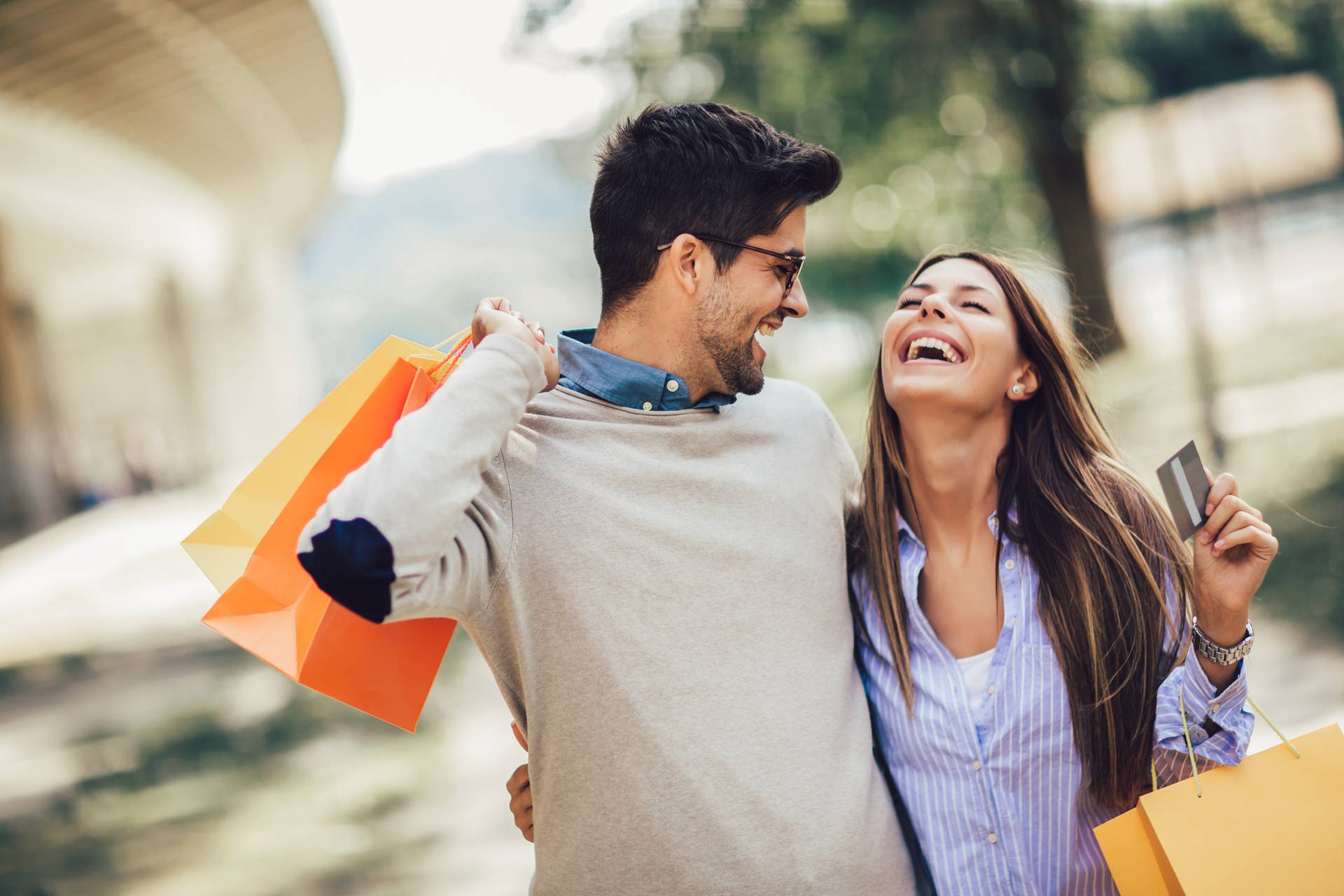 Young couple with shopping bags and credit card in the city