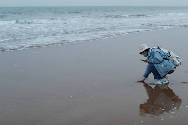 People walk at the beach in Qingdao, Shandong province