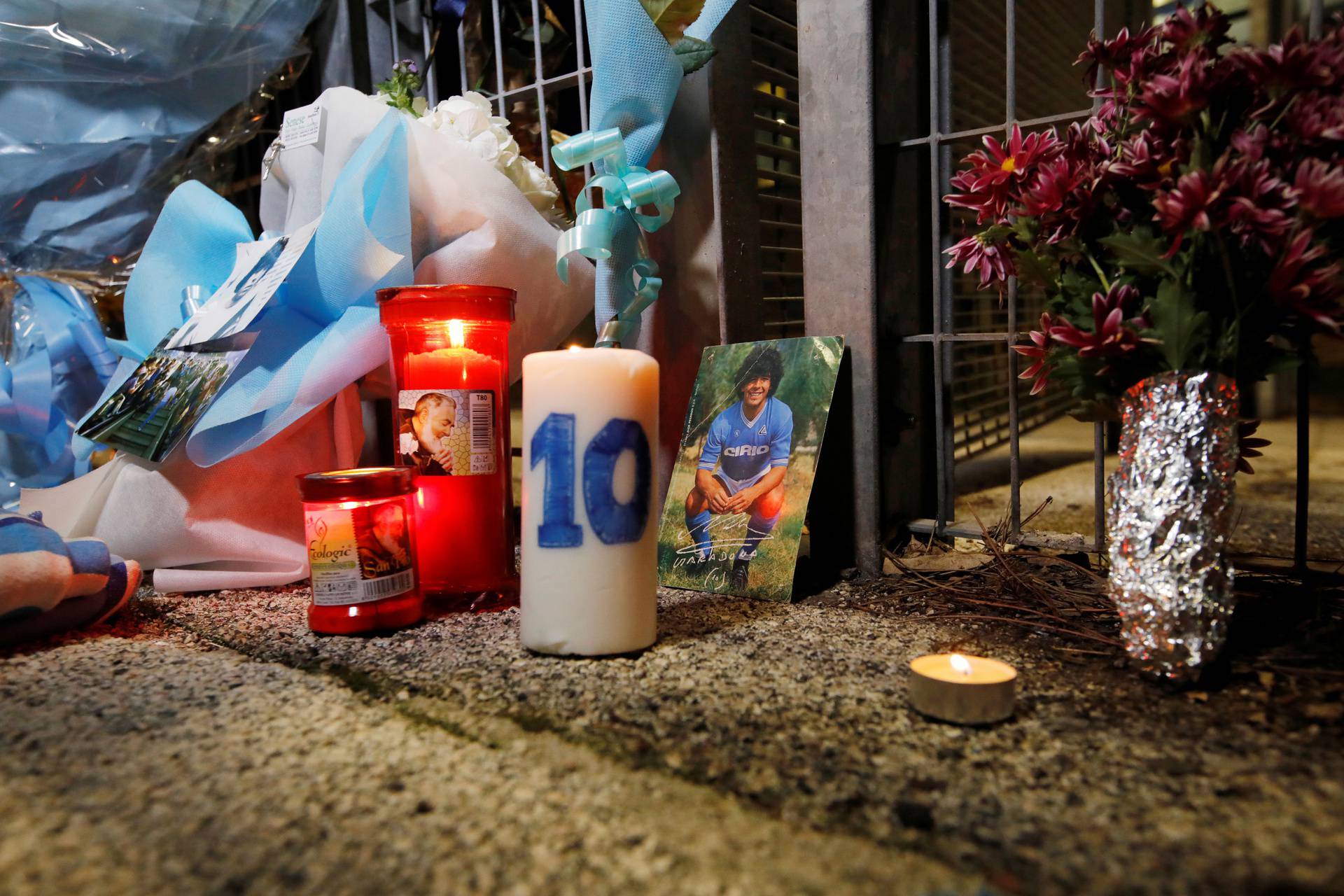 People gather to mourn the death of Argentine soccer legend Diego Maradona outside San Paolo stadium in Naples