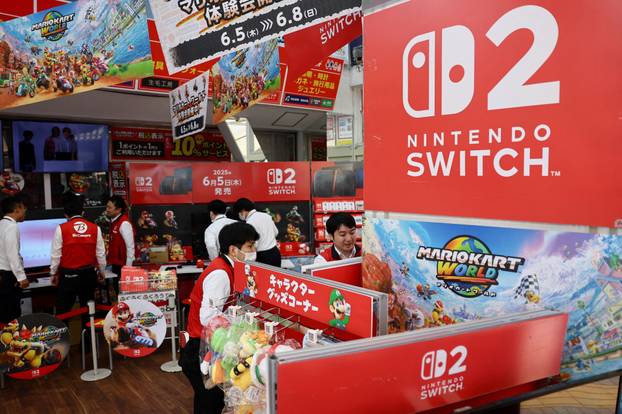 Staff members work on the day Nintendo starts selling the Nintendo Switch 2 game console globally, at an electronics store, in Tokyo