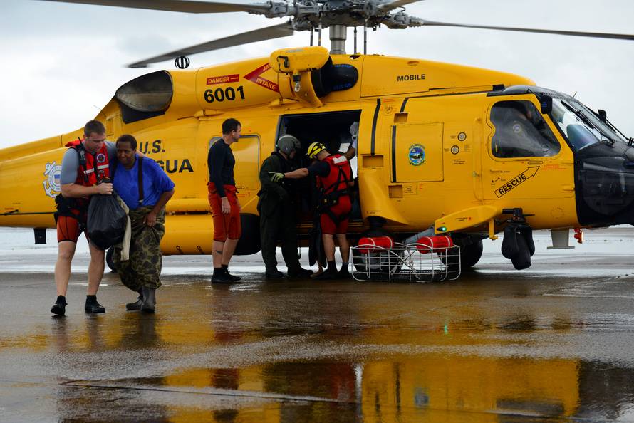 Evacuees leave a U.S. Coast Guard helicopter after being rescued from flooding due to Hurricane Harvey in Houston