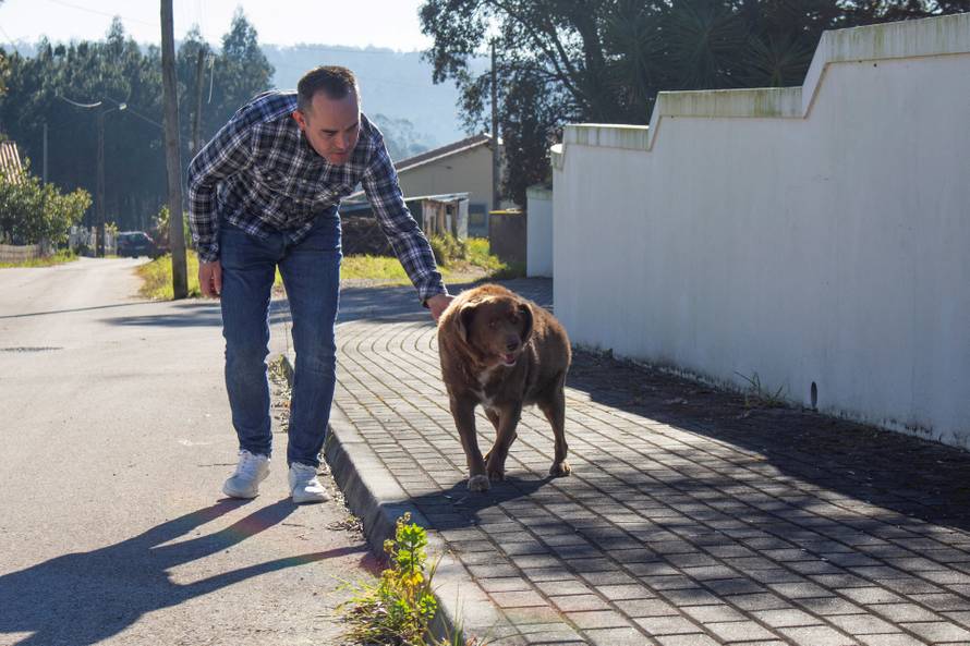 FILE PHOTO: Leonel Costa walks the dog, Bobi, that broke the record for oldest dog ever at 30 years-old, at Conqueiros, in Leiria