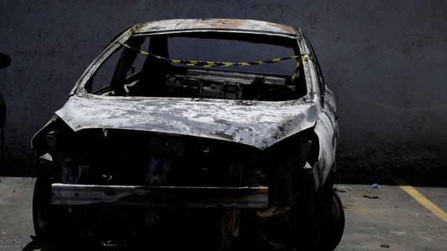 A burned car in which a body was found during searches for the Greek Ambassador for Brazil Kyriakos Amiridis, is pictured at a police station in Belford Roxo