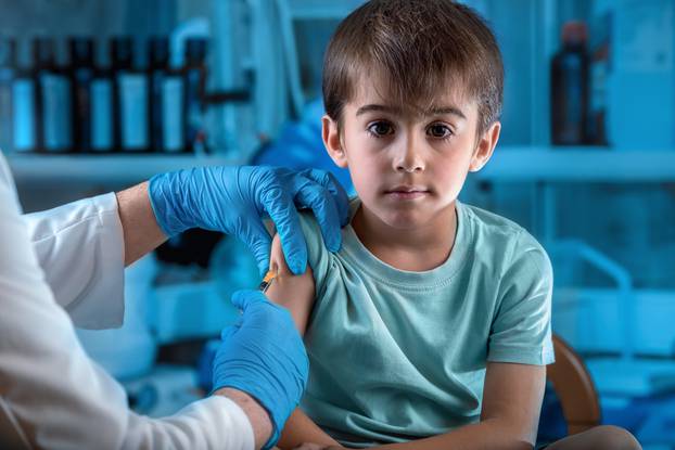 doctor injecting vaccine preventive to little boy in the hospita