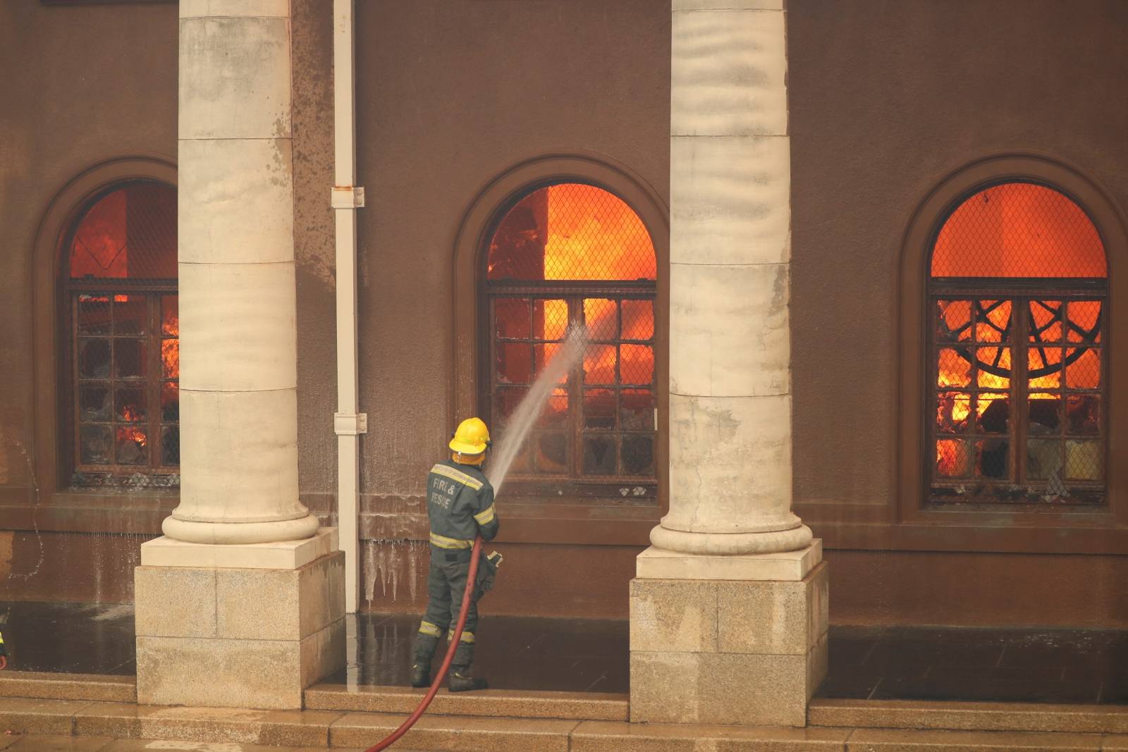 Firefighters battle flames as the library at the University of Cape Town burns, in Cape Town