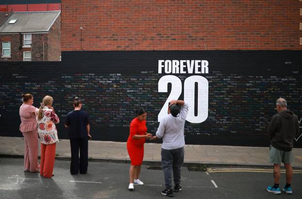 Fans look at messages written onto a memorial wall created near Anfield Stadium following the death of Liverpool soccer player Diogo Jota in Liverpool
