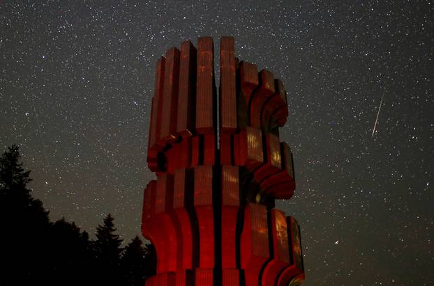 Meteor streaks across skies near the Monument to the Revolution in Prijedor