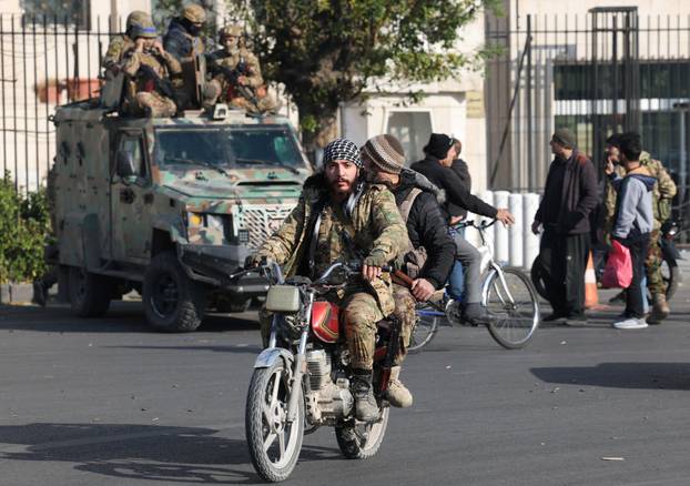 Rebel fighters ride a motorbike, in Damascus