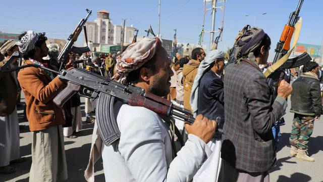 Newly recruited Houthi fighters hold up firearms during a ceremony at the end of their training in Sanaa
