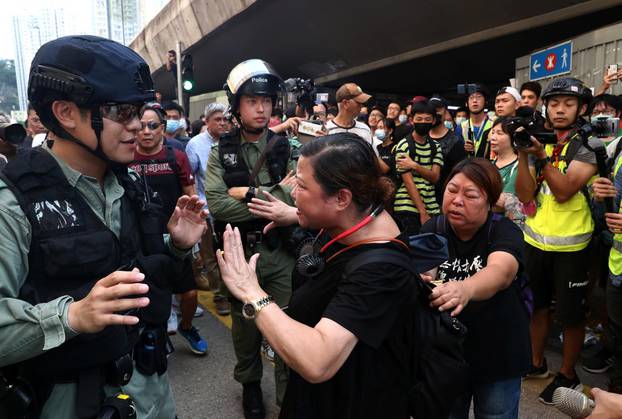 An anti-government protester argues with a riot police officer near Amoy Plaza shopping mall in Kowloon Bay, Hong Kong