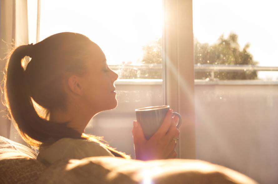 Girl enjoying morning coffee in living room