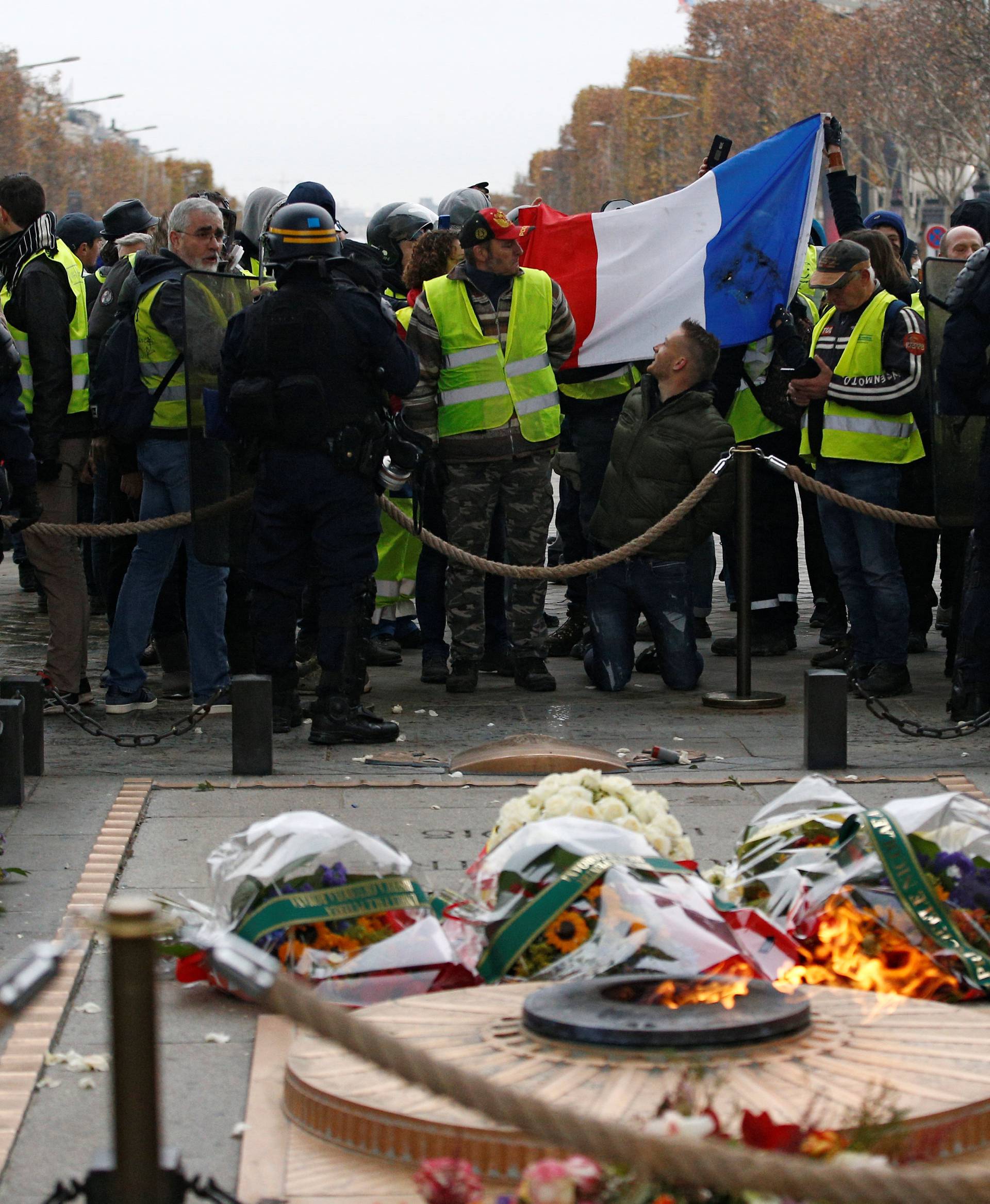 Riot police secure the Tomb of the Unknown Soldier as protesters wearing yellow vests, a symbol of a French drivers' protest against higher diesel taxes, demonstrate in Paris