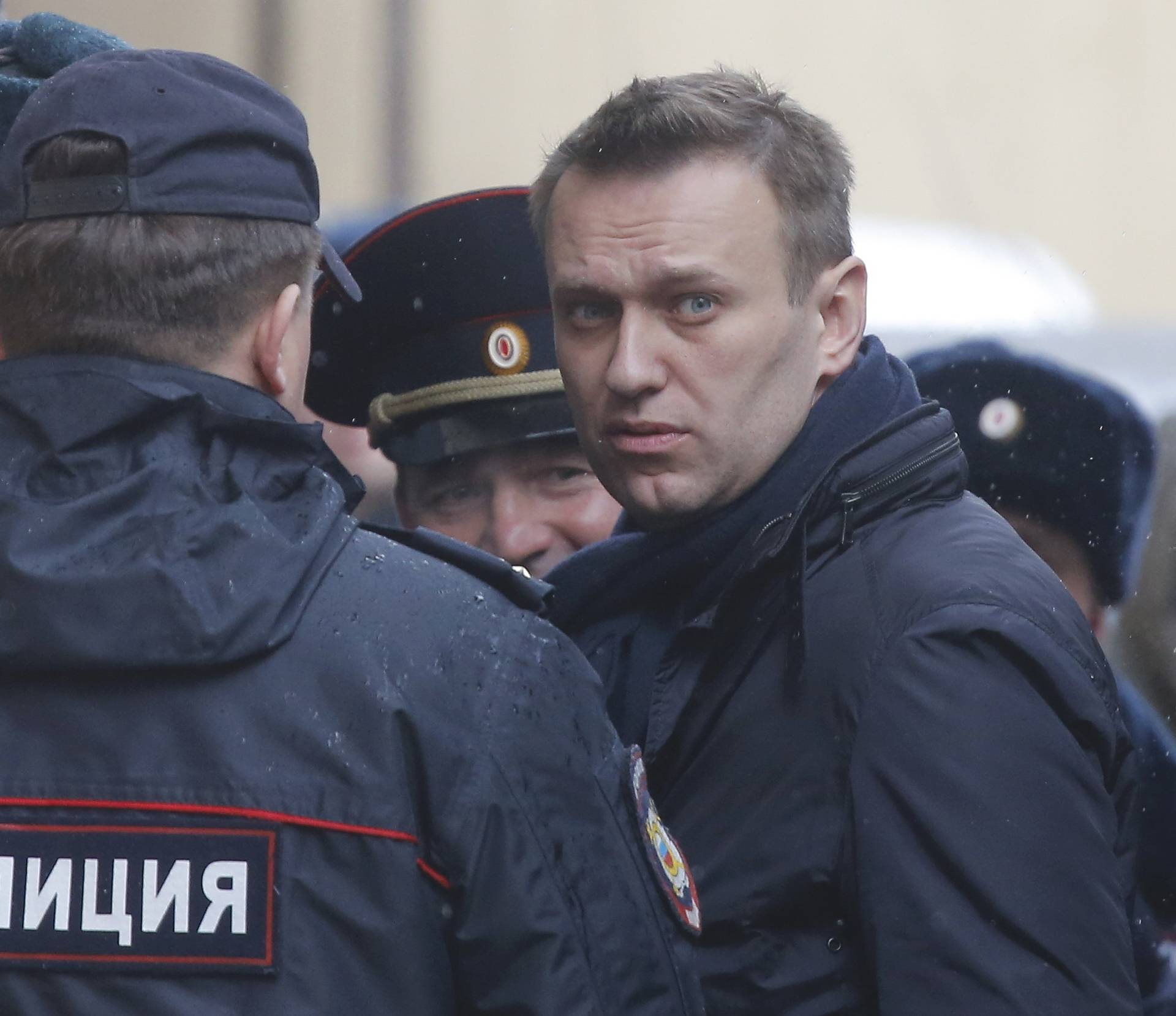 Russian opposition leader Navalny is escorted upon his arrival for hearing after being detained at protest against corruption and demanding resignation of PM Medvedev, at Tverskoi court in Moscow